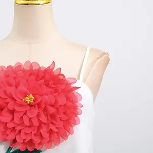 Detailansicht der großen roten 3D-Blumendekoration auf einem weißen Sommer-Trägerkleid