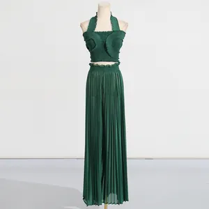 Detail view of green pleated two-piece set with halter top and wide-leg pants