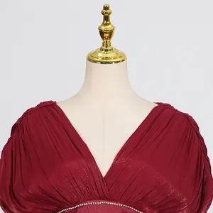Detailansicht eines eleganten weinroten Kleides aus Satin mit V-Ausschnitt und Falten.