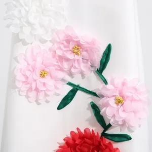 Detailansicht der aufwendigen 3D-Stoffblumenapplikationen auf einem weißen Sommerkleid.