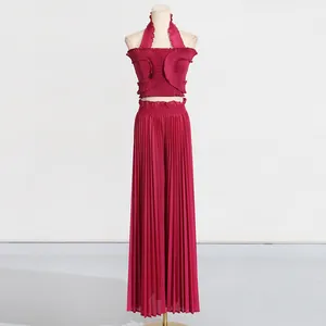Close-up detail of the ruffled halter top and pleated texture on the high-waisted wide leg pants.