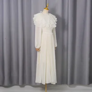 Detailed view of elegant white pleated chiffon dress with ruffled collar and lantern sleeves