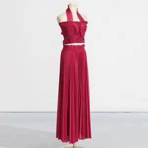 Detailed view of magenta pleated two-piece set with halter neck top and wide-leg pants