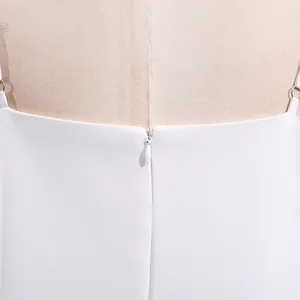 Detaillierte Makroansicht des hochwertigen verdeckten Reißverschlusses am weißen Trägerkleid.