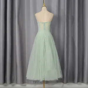 Elegant back view of mint green tulle dress with floral embroidery displayed on mannequin
