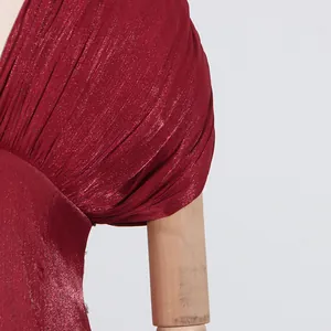 Detailaufnahme der plissierten Schulterpartie eines weinroten Satin-Abendkleids