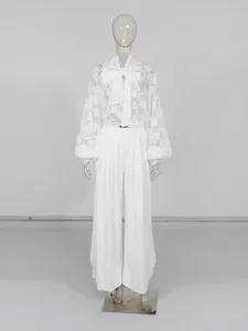 Elegante set estivo bianco con camicetta di pizzo con fiocco e pantaloni larghi spaccati