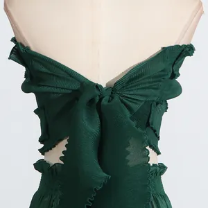 Close-up back view of dark green pleated off-shoulder top featuring a large bow and ruffles