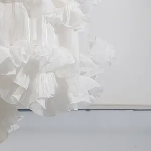 Detalle de primer plano de los delicados volantes blancos en un elegante vestido largo