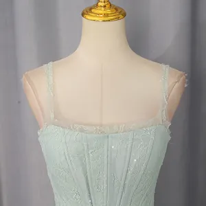 Close-up of light green lace embroidery dress with delicate sequins and mesh straps
