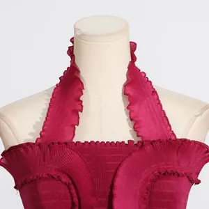 Detailed close-up showing the pleated texture and ruffle trim of a deep magenta halter top