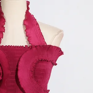 Close-up of fuchsia pleated halter top featuring elegant ruffle details and fine texture