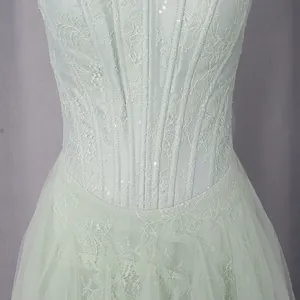 Close-up of court style lace embroidery and sequins on a mint green mesh gown