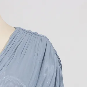 Makrodetail aus hochwertigem, plissiertem Satinstoff an einem hellblauen Luxuskleid