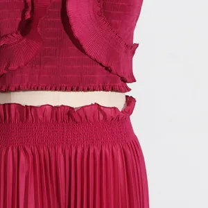 Close-up of pleated texture on a burgundy two-piece set with ruffle details