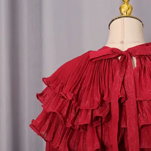 Close-up of red pleated chiffon dress featuring back bow tie and tiered ruffles