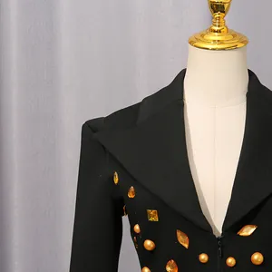 Detailed view of luxury black blazer dress with vintage gold rhinestones and amber gems