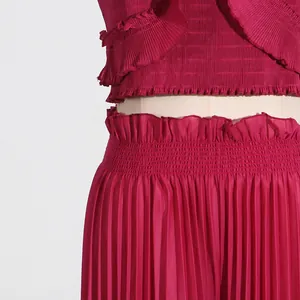 Detail macro view of the pink pleated fabric set featuring a ruffle top and high waist pants