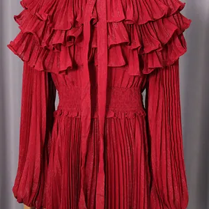 Close-up of red pleated chiffon dress with elegant ruffles and bow-tie neck detail.