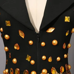 Close-up detail of a vintage black suit dress with gold pearls and amber gem embellishments