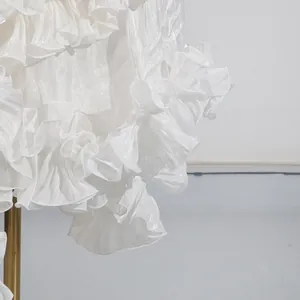 Primer plano detallado de volantes blancos en tejido brillante de vestido de fiesta