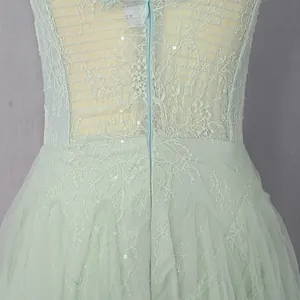 Close-up of mint green lace embroidery and mesh patchwork detail on dress