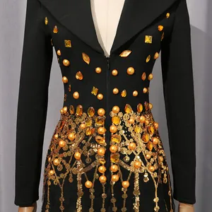 Close-up of luxury black blazer dress with gold sequins, fringe, and rhinestones.