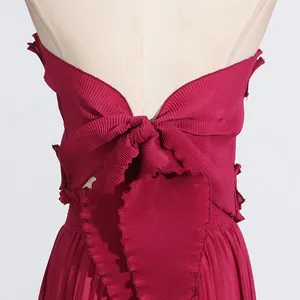 Close-up back detail of red pleated halter top featuring a large decorative bow tie