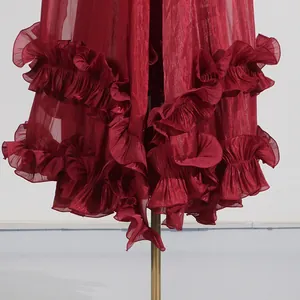 Vista detallada del dobladillo de un elegante vestido rojo con volantes en capas