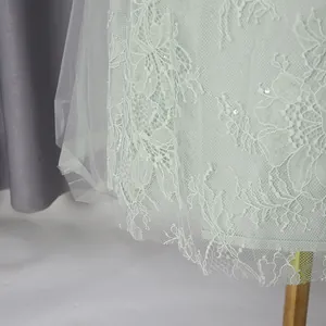 Detailed view of exquisite lace embroidery and sequins on light green mesh dress