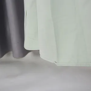 Close-up of the irregular hemline and stitching of a mint green palace style dress.