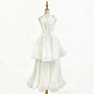 Detailed view of an elegant white halter sleeveless pleated tulle maxi dress for summer