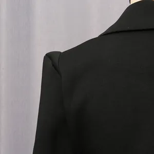 Close-up showing the pleated shoulder detail of a black vintage palace style blazer dress.