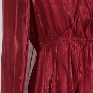 Primer plano de vestido plisado rojo vino con tejido texturizado y detalle en cintura