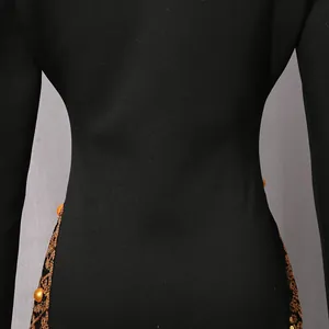Detail showing exquisite golden sequins and lace embroidery on a luxury black blazer dress.