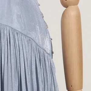 Detailaufnahme des hellblauen, plissierten Satinstoffs eines hochwertigen Sommer-Maxikleids