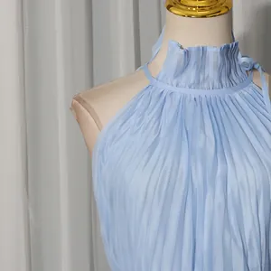 Detail view of a light blue pleated halter neck dress with ruffle collar