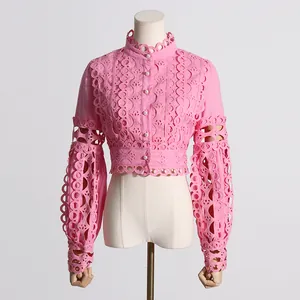 Blusa de encaje rosa vintage con mangas abullonadas y patrones florales calados.
