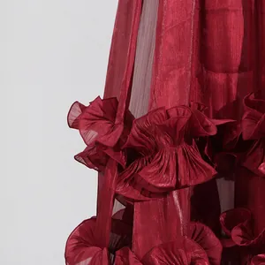 Detalle de tela brillante rojo vino con volantes plisados en el vestido de noche