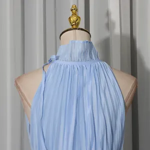 Detailed close-up showing the pleated high neck and fabric of a light blue halter dress
