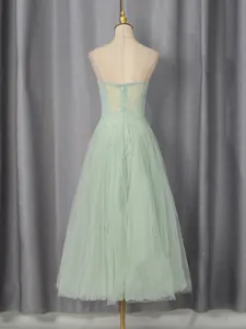 Elegant mint green mesh bridesmaid dress with embroidery and sequins shown from back view.
