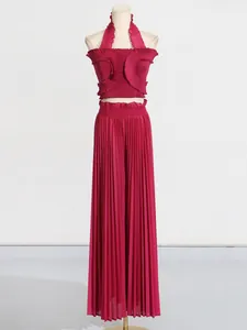 Elegant pleated two-piece set with halter ruffle crop top and wide-leg pants in magenta