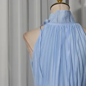 Detail view of light blue pleated high neck sleeveless gauze dress with delicate ruffles