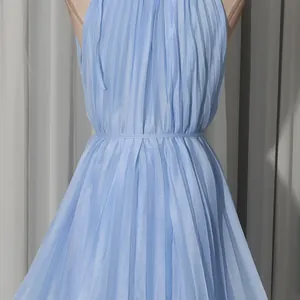Detailed view of the pleated texture and waistline on a light blue halter dress