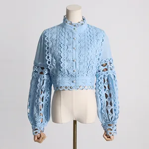 Detalle de una blusa vintage francesa de encaje calado azul con mangas de princesa