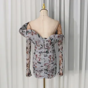 Vista posteriore di un elegante mini abito a fiori con arricciature e spalle scoperte su manichino