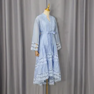 Vista detallada del bordado de encaje azul claro en un vestido largo con volantes de estilo francés.