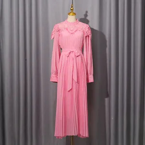 Full-length view of a pink pleated chiffon dress displayed on a dress form mannequin