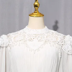 Close-up of elegant white chiffon dress with intricate lace neck and pleated detail