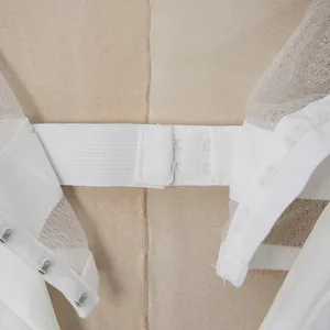 Vista dettagliata della chiusura posteriore con ganci di un elegante abito da cocktail bianco
